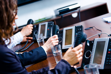 Close-up of hands holding landline phone recievers