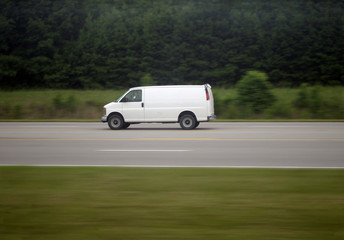 Fototapeta na wymiar Biały van przyspieszenie w dół wsi autostrady