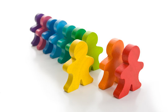Line of colorful wooden people - one person stand out of line.