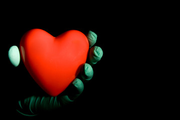 A medical professional holding a red heart.