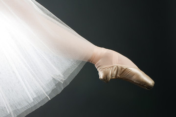legs in ballet shoes on a black backgrounde