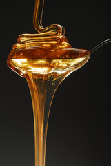 Sweet honey spilling over the spoon stock photo