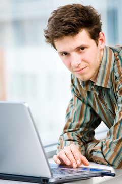 Casual looking happy businessman working on laptop