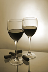 Two glasses with red wine with bottle corks