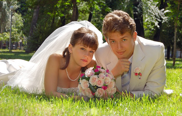 The groom and its bride have a rest on a lawn