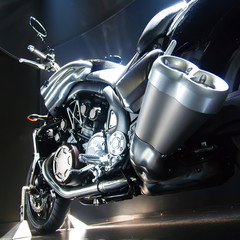 Motorbike with big exhaust pipe against a dark background.