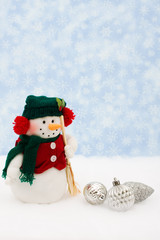 Silver glass Christmas balls and snowman on snow