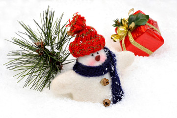 One woolen snowman dressed in scarf and hat in the snow