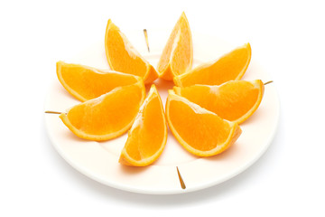 Orange cut into eight pieces on white plate.