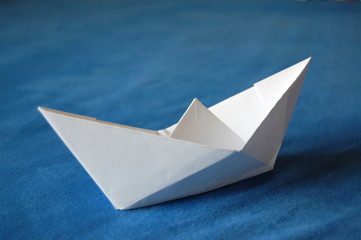 origami paper boat isolated on blue water