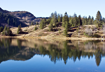 Fototapeta na wymiar Reflections in the water of mountain lake