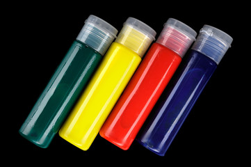 Tubes of colorful face paint isolated on black background