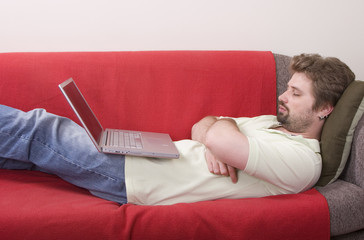 young man fall asleep while working on the laptop