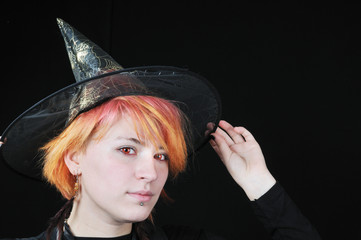 portrait of nice witch with hat on black background