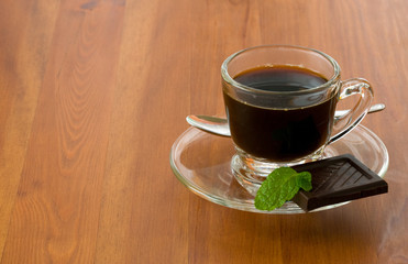 a coffee cup with black piece of dark chocolate