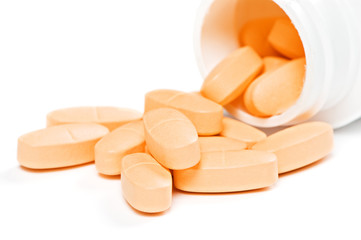 closeup of yellow pills over white background