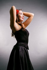 Fototapeta premium happy woman in black dress. studio shot over grey background