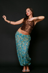 young girl dancing in indian clothes over black