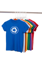 A group of brightly colored t-shirts with a recycle symbol