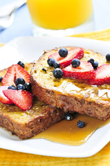 Breakfast of french toast with fresh berries and maple syrup