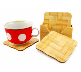 Colored cup and set of wooden trivets isolated