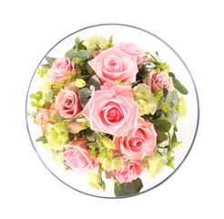 Looking down into a glass bowl full of pink and cream roses.