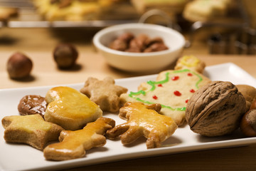 handmade christmas cookies on a plate, nuts in background