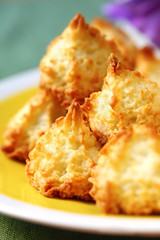 Coconut macaroons on a sunny yellow plate.