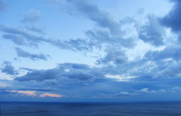 Naklejka na ściany i meble Zachód słońca z dużych deszczowych chmur nad morze