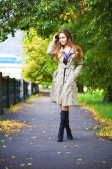 Young woman walking in autumn park.