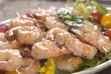 sauteed Shrimp on skewers over a bed of salad