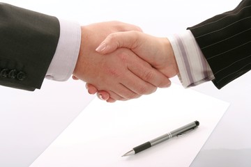 Business handshake over page with pen