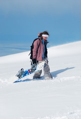 Young lady snowboarder walking