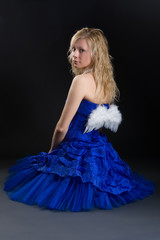 Beautiful girl in a dark blue dress with white wings