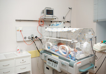 newborn baby sleeping in an incubator in hospital. - obrazy, fototapety, plakaty
