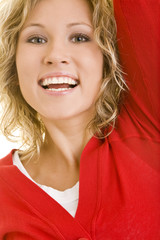 Junge blonde Frau springt jubelnd in die Luft
