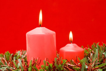 Red candles of Christmas lit on a over red background