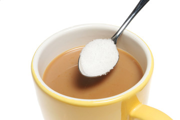 Closeup of a mug of coffee and spoonful of sugar