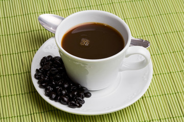 Cup of expresso coffee on a green tablecloth