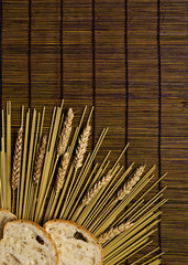 brown bamboo board background with italian pasta and grain