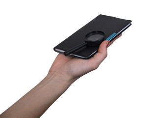 The female hand holds a small notebook on a white background