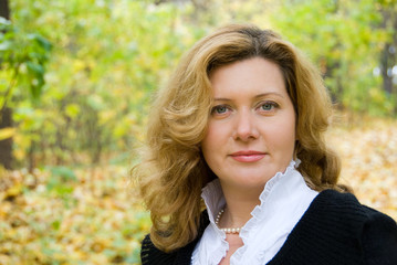 Fototapeta premium Middle age woman portrait in an autumn nature
