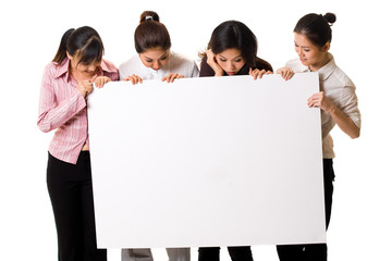 four girls lloking at a white sign