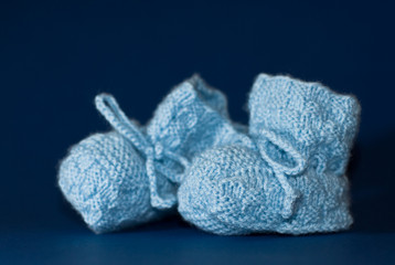 Two blue baby shoes on dark blue background