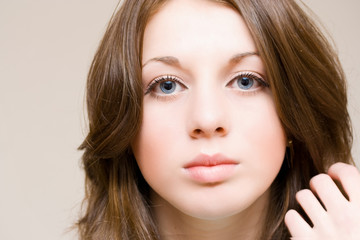 Naklejka premium Beautiful girl with blue eyes arranging her hair, isolated