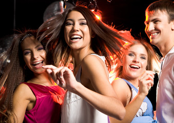Portrait of laughing girl dancing among her friends