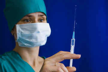 The nurse holds in his hand a syringe with medicine