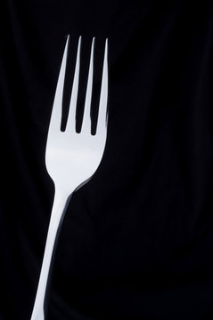 a silver fork on a black background