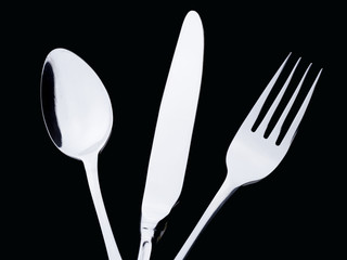 a silver spoon knife fork on a black background