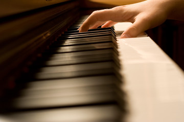 Fototapeta na wymiar The hand on piano keyboard